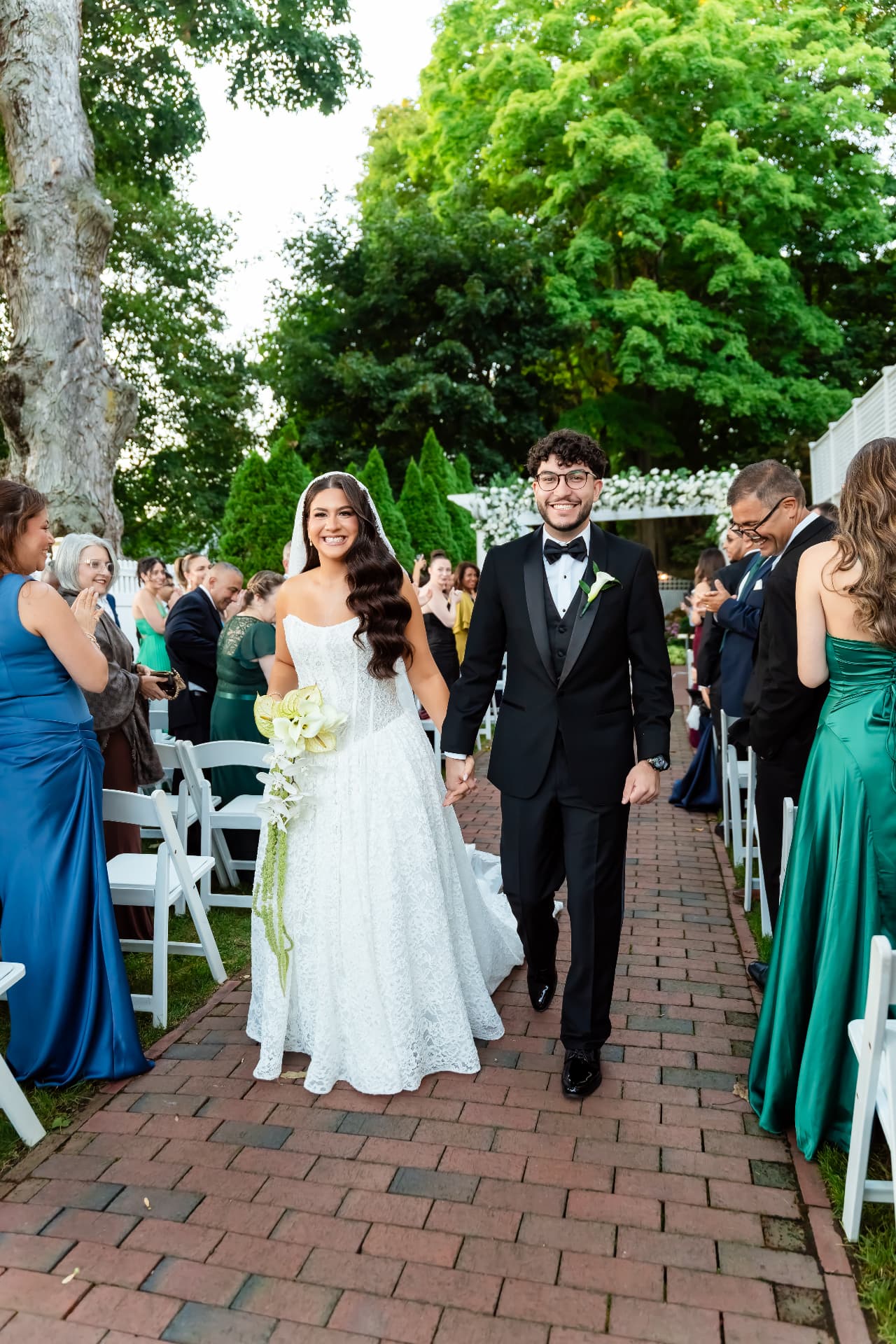 Bride and groom walking down the aisle among their wedding guests