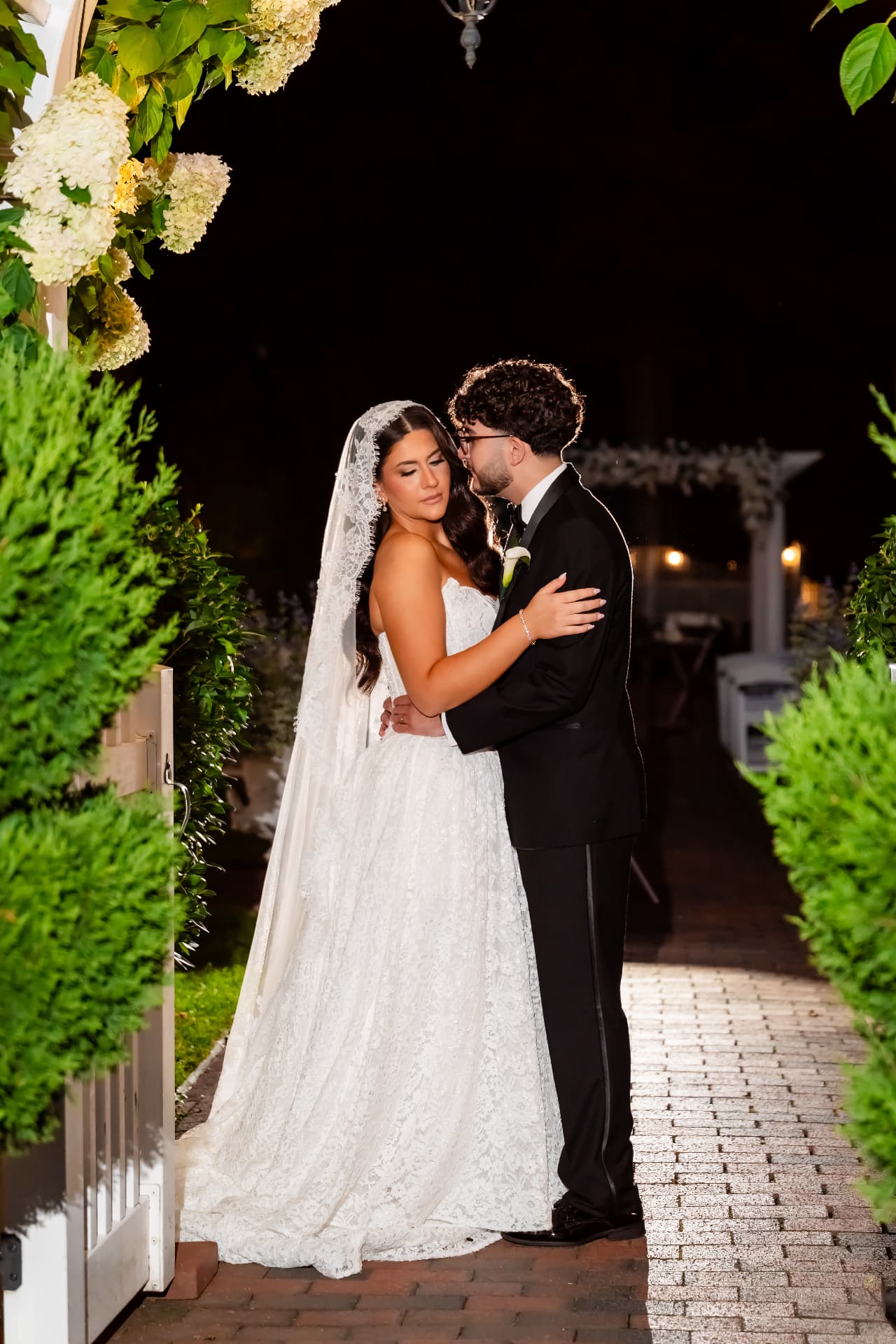 Bride and groom together beneath an illuminated arch