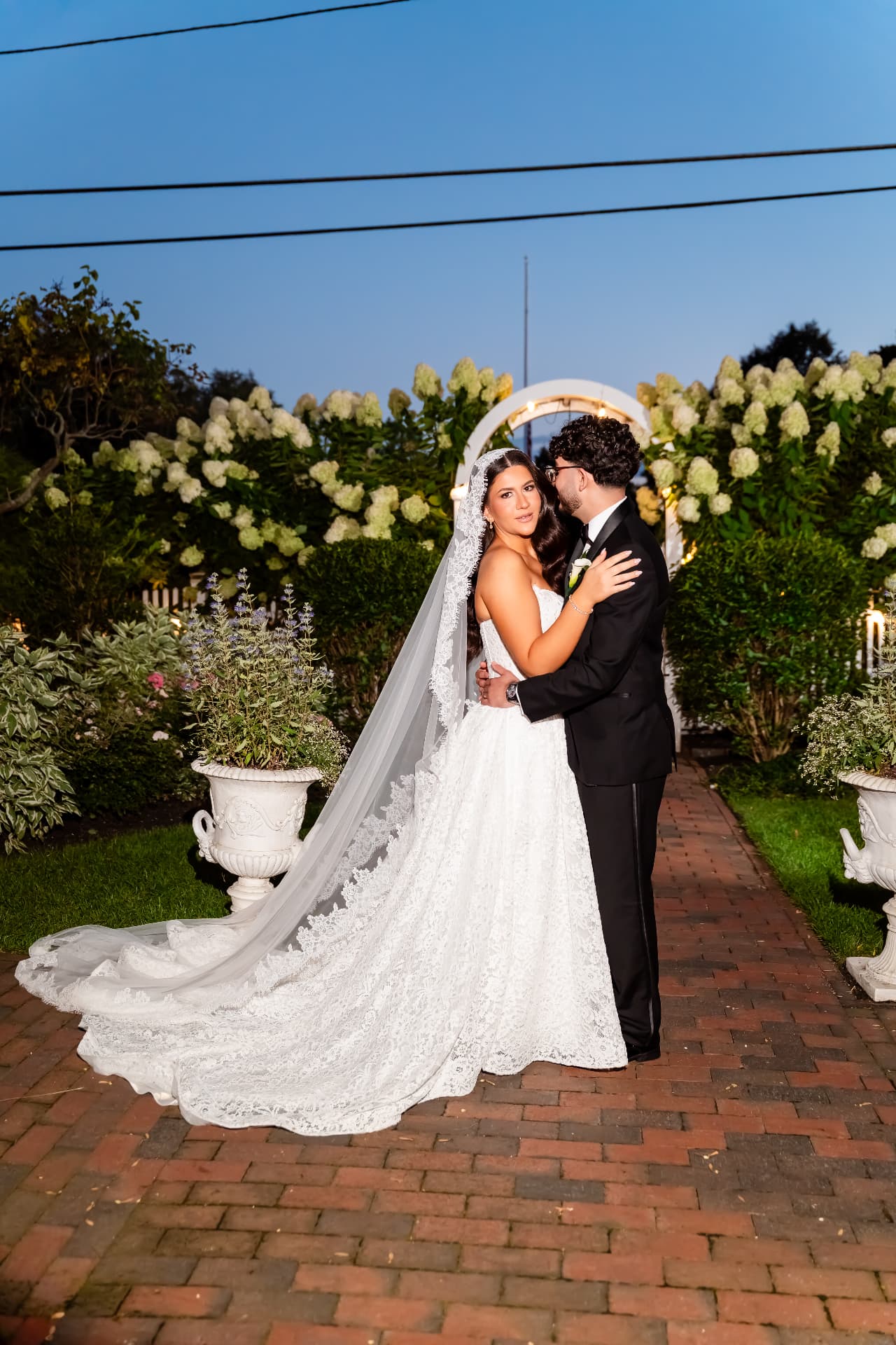 Bride's veil and wedding dress beside her groom