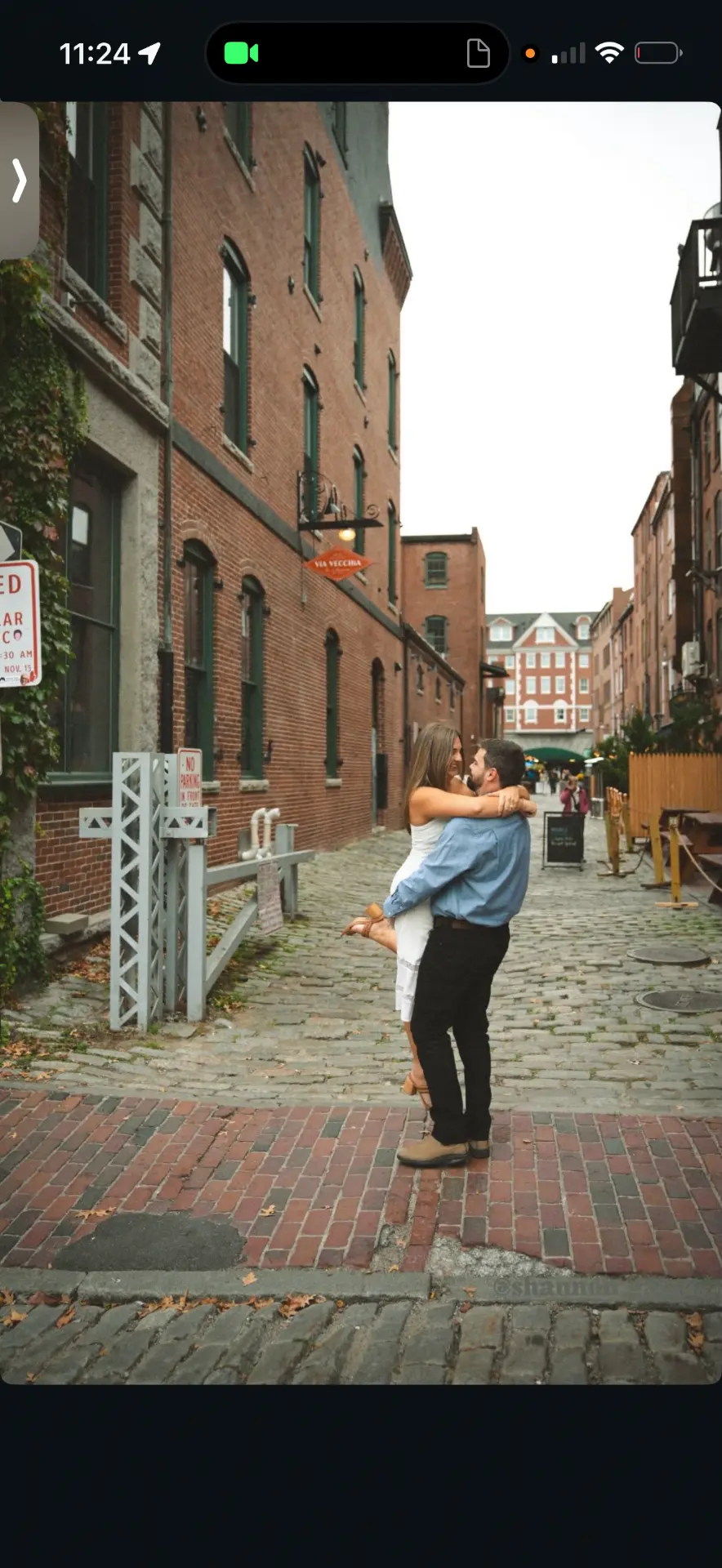 Engagement couple embracing on a brick-lined street