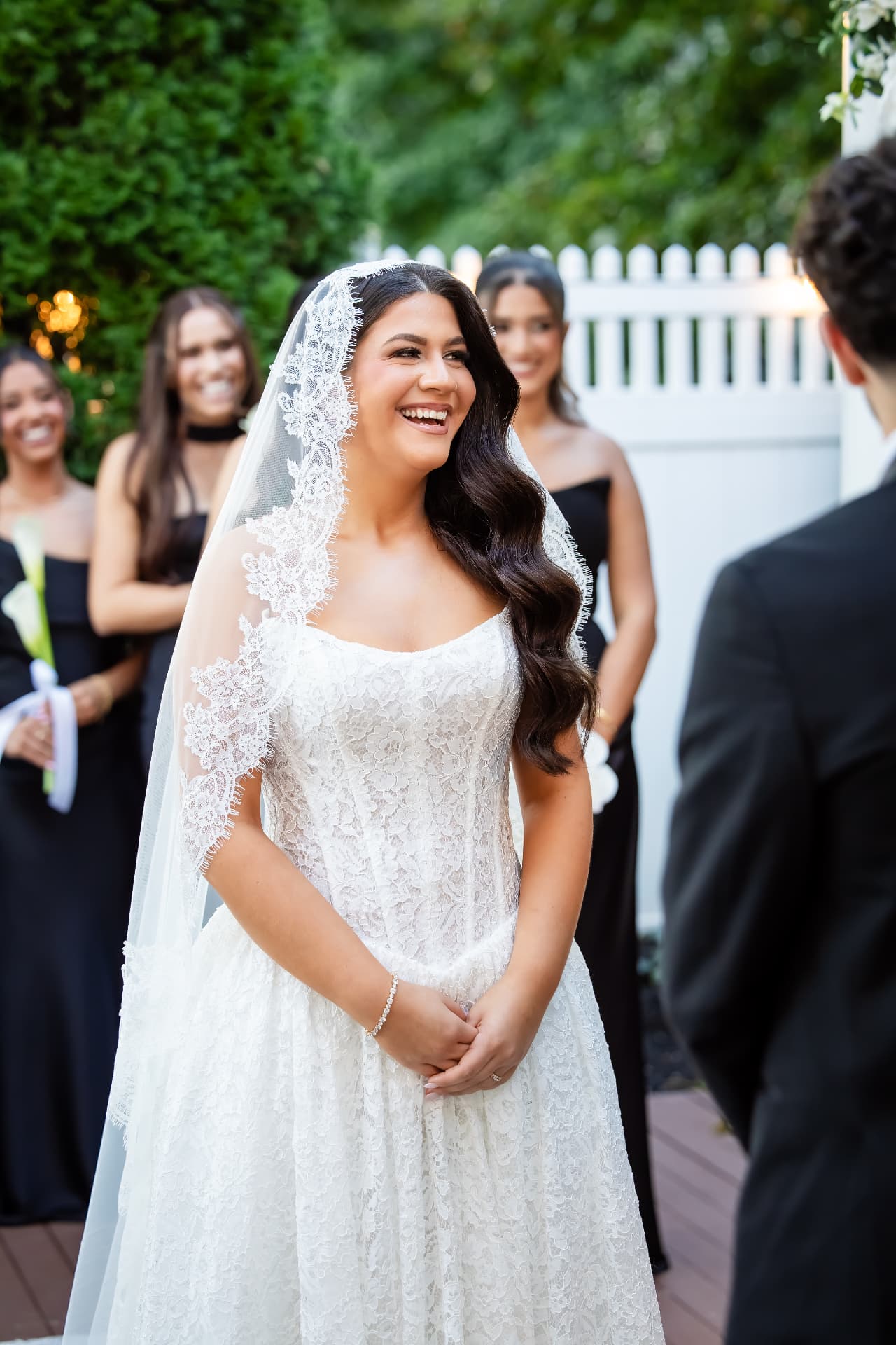 Bride smiling at her groom during an outdoor wedding ceremony